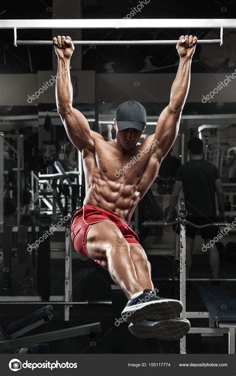Muscular Man Working Out In Gym Doing Stomach Exercises On A