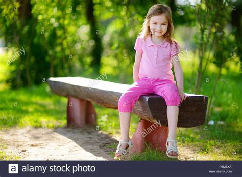 Download This Stock Image Adorable Little Girl Sitting On A Bench In A