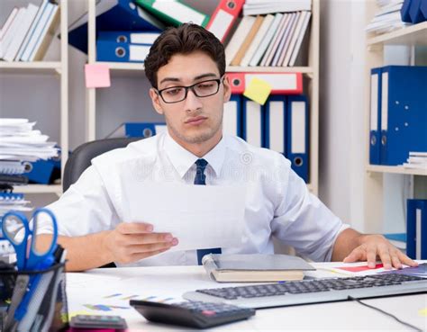 Businessman Working In The Office With Piles Of Books And Papers Stock
