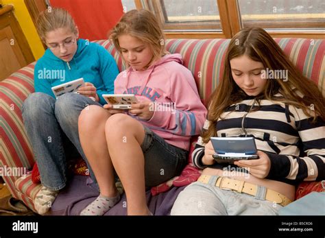 gruppe von drei jungen 14 jahre alten mädchen im teenageralter auf sofa mit computerspielen auf