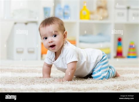Funny Baby Boy Crawling On Floor In Nursery Or At Home Stock Photo Alamy