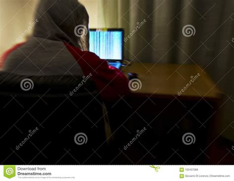 Blurred Image From Behind Of An Hacker With A Sweatshirt And Hood