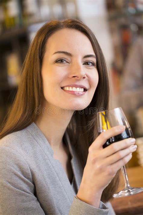 Portrait Of Pretty Young Woman Drinking Red Wine In Restaurant Stock