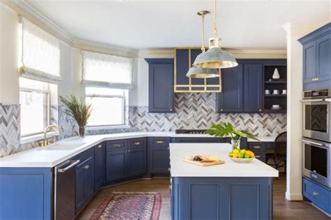 Chic kitchen features blue cabinets adorned with gold pulls paired with white marble countertops and matching backsplash. 10 Blue-tiful Kitchen Cabinet Color Ideas | HGTV