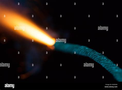 Close Up Of Burning Fuse With Sparks And Blue Smoke On Black Background