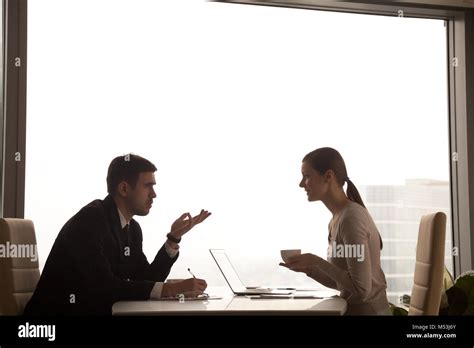 Employees Talking About Business At Desk In Office Stock Photo Alamy