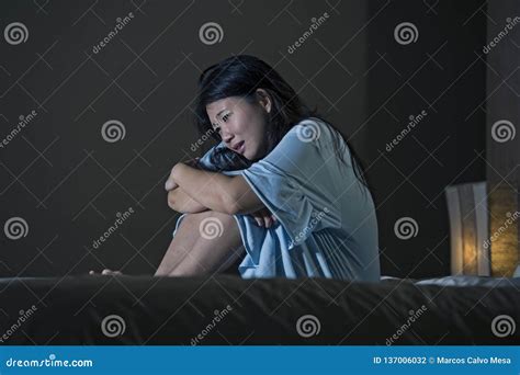 Dramatic Portrait Of Young Beautiful And Sad Asian Korean Woman Crying Desperate On Bed Awake At