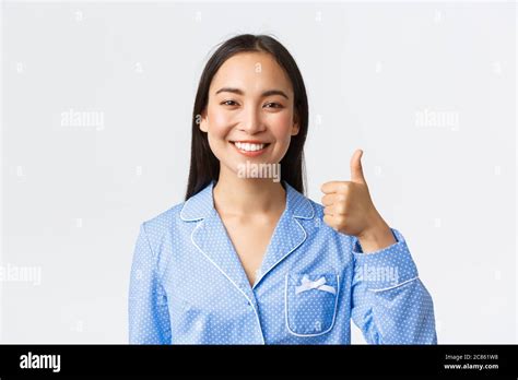 Close Up Of Satisfied Pretty Smiling Asian Woman In Blue Pajama Showing