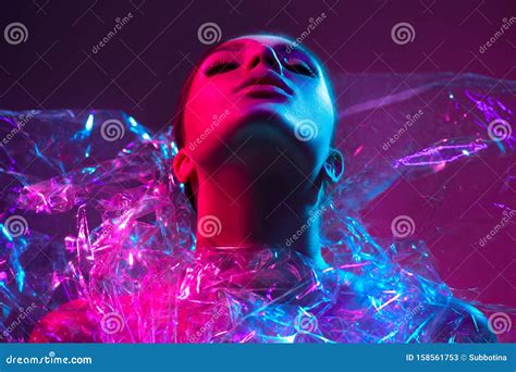 High Fashion Model Girl In Colorful Bright Neon Lights Posing In Studio Through Transparent Film