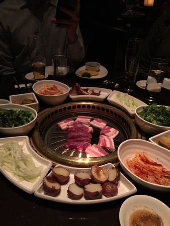 There are endless combinations of bases, sauces, and toppings for you to customize and enjoy. Korean BBQ table with grill in center and side dishes ...