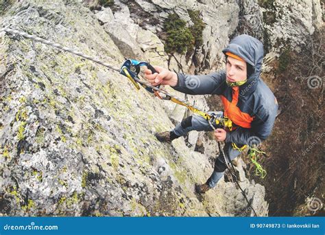 Young White Man Climbing A Steep Wall In The Mountains Climbing