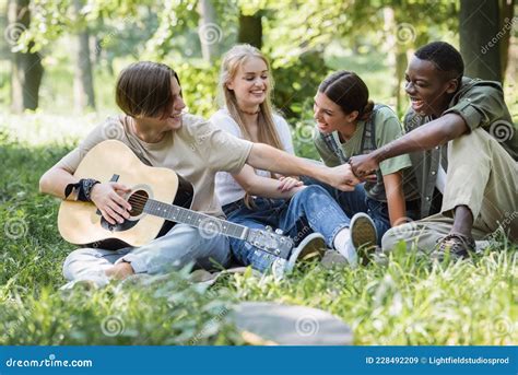 Adolescentes Interraciales Con Guitarra Acústica Haciendo Imagen de archivo Imagen de
