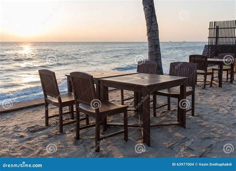 Wooden Chairs On The Beach At Sunrise With A Tropical Sea Stock Photo