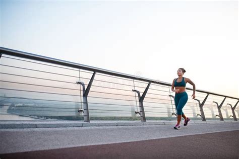 Overweight Dark Skinned Woman Running In The Morning Stock Photo