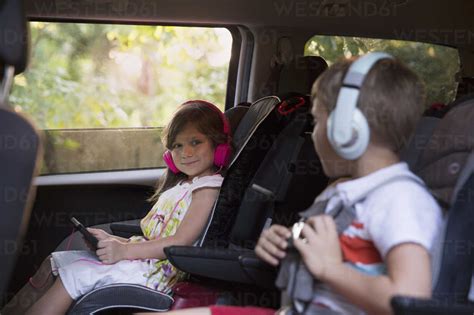 Junge Und Jüngere Schwester Tragen Kopfhörer Und Benutzen Ein Digitales Tablet Auf Dem Rücksitz