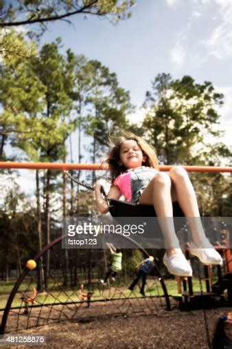 Elementary Girl Swings At Park Or School Playground High Res Stock