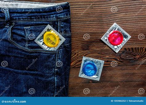 Safe Sex With Condom Contraception In Jeans Pocket On Wooden Bac Stock