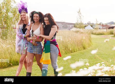 Female Friends Walking Back To Tent After Outdoor Music Festival Stock