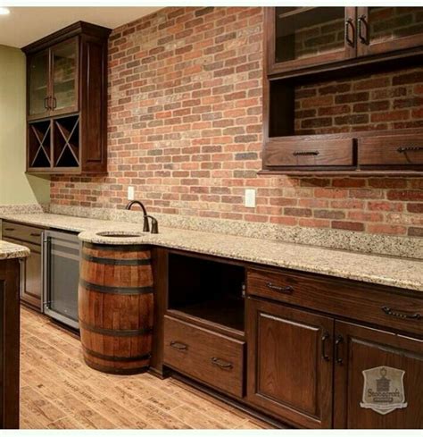 A Kitchen With Wooden Cabinets And An Island In Front Of A Brick Wall