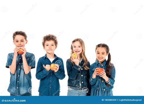Four Children In Denim Clothes Eating Apples Isolated On White Stock