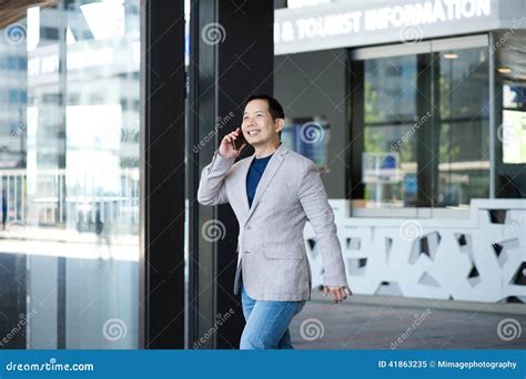 Man Exiting Building With Mobile Phone Stock Image Image Of Aged