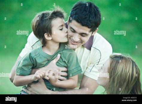 Boy With Parents Kissing Father On Cheek Stock Photo Alamy