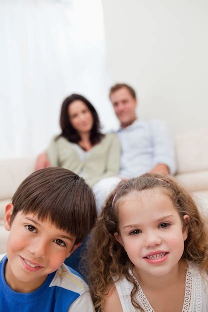 Premium Photo Children Sitting In The Living Room With Parents Behind