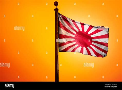 The Old Flag Of Japan On A Flagpole Isolated On An Orange Background