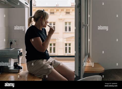 Mature Woman Smoking E Cigarette At Home Near The Window Caucasian 40