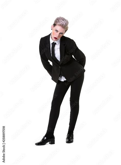 short haired blonde model in a suit shirt and tie leaning forward looking at the camera