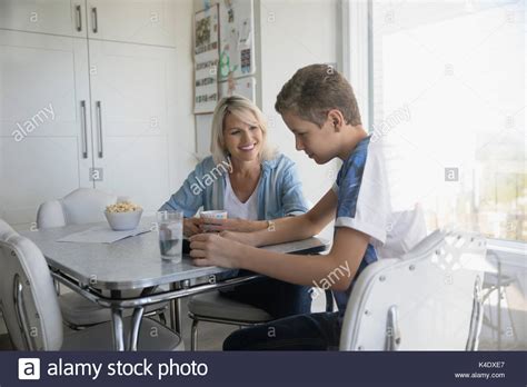 Mother And Pre Adolescent Son Talking At Kitchen Table Stock Photo Alamy