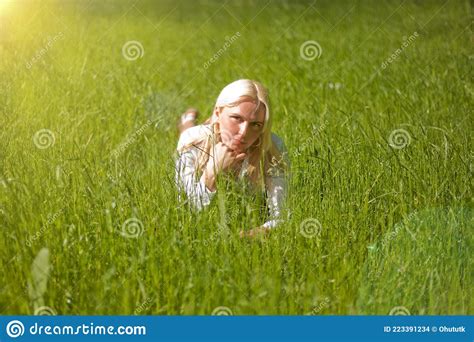 Peaceful Girl Lying On Green Grass With Stretched Arms And Legs Blond Woman Lying On The Grass