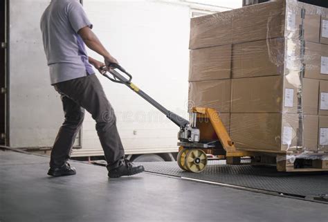 Warehouse Worker Unloading Cargo Pallet Out Of The Inside Container Truck Shipment Boxes
