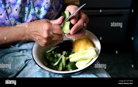 Granny Hands Peel Fresh Cucumber With Knife And Cut Into Pieces