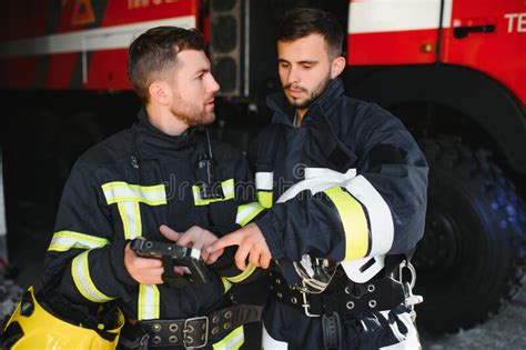 portrait of two firefighters in fire fighting operation fireman in protective clothing and