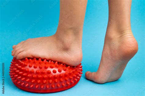 Childrens Feet With A Red Balancer On A Light Blue Background