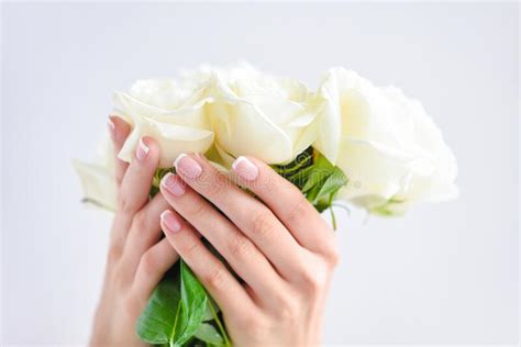 Hands Of A Woman With Beautiful French Manicure And Bouquet Of White