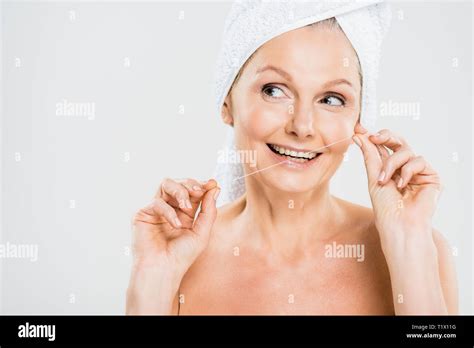 Attractive And Smiling Mature Woman In Towel Brushing Teeth With Dental