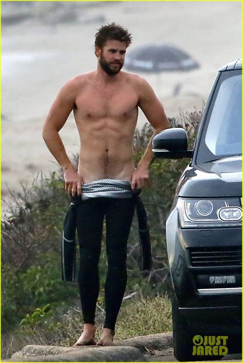 Liam Hemsworth Bares Ripped Abs While Stripping Out Of Wetsuit Photo