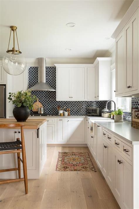 Black backsplash tiles with white cabinets