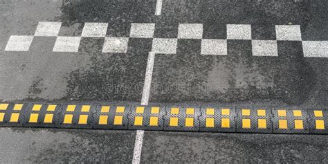 Speed Bump Of Black And Yellow Colours On Asphalt Road Stock Photo