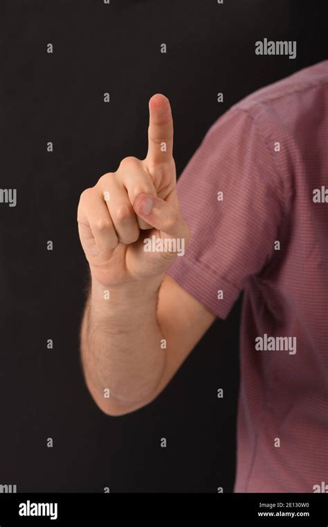 Man Hand Holds Index Finger Up Isolated On Black Background High