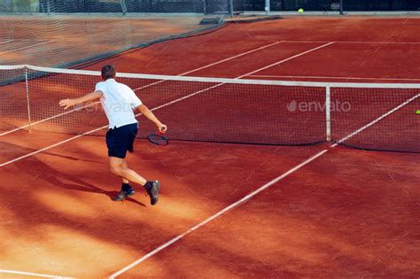 Back View Of A Man Playing Tennis On Tennis Court Stock Photo By