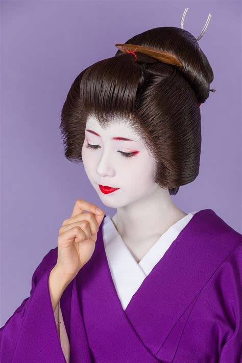 A Geisha Doll Wearing A Purple Kimono