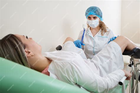 premium photo gynecologist preparing for an examination procedure for a woman sitting on a
