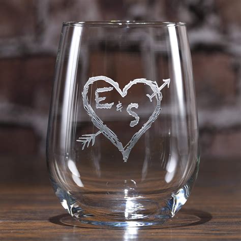 A Wine Glass With An Arrow And Heart Etched On It