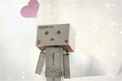 A Small Robot Is Standing In Front Of A Wall With A Heart On Its Head