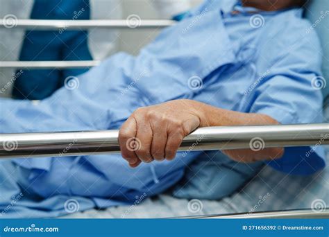 Asian Elder Senior Woman Patient Holding Bed Rail While Lie Down With