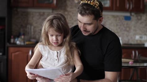 Dad And Daughter Are Watching Her Pictures Girl Shows Her Drawings To