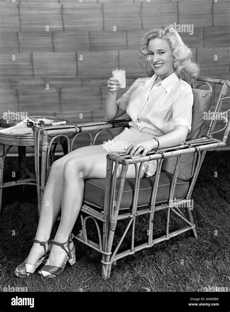 1940s Blonde Woman In Bamboo Chair Holding Up Glass Of Milk Smiling